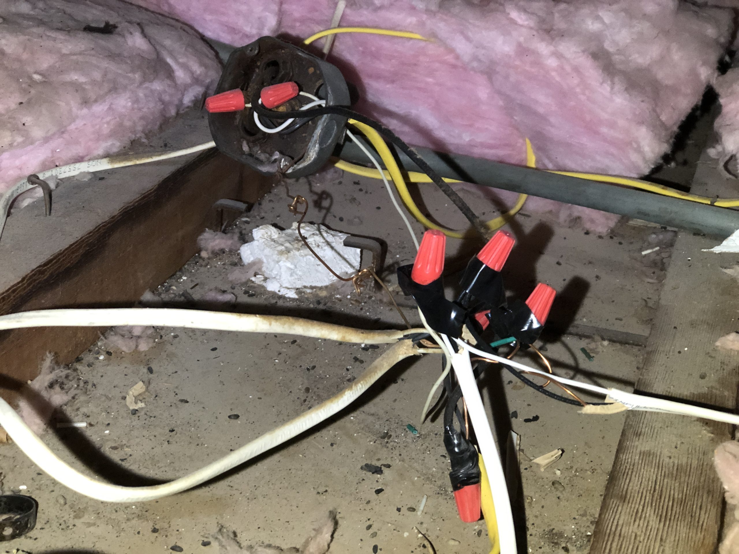 Uncovered electrical splices with wire nuts and tape in an attic during a home inspection in Encinitas, California